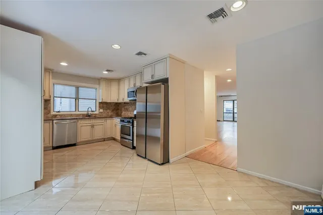 a kitchen with a refrigerator and white cabinets