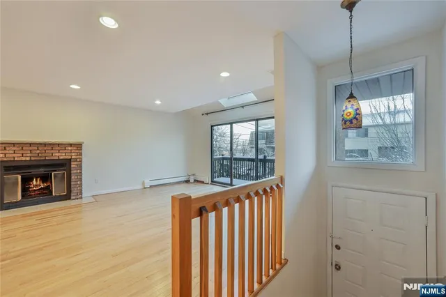a view of an empty room with a fireplace and a window