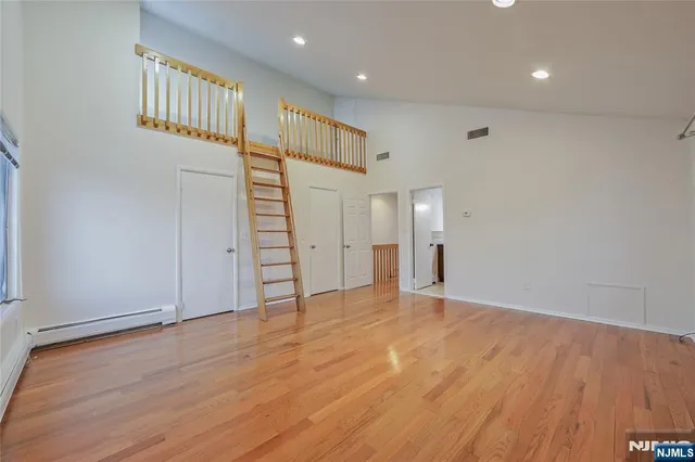 a view of an empty room with wooden floor