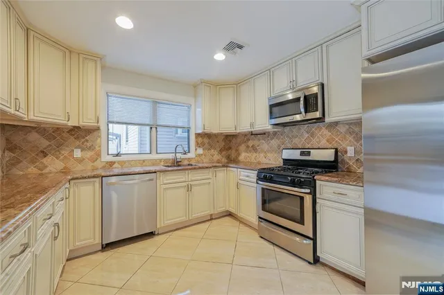 a kitchen with granite countertop cabinets stainless steel appliances and a sink
