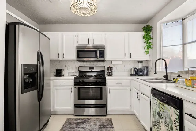 a bedroom with a bed and a flat tv screen on dresser