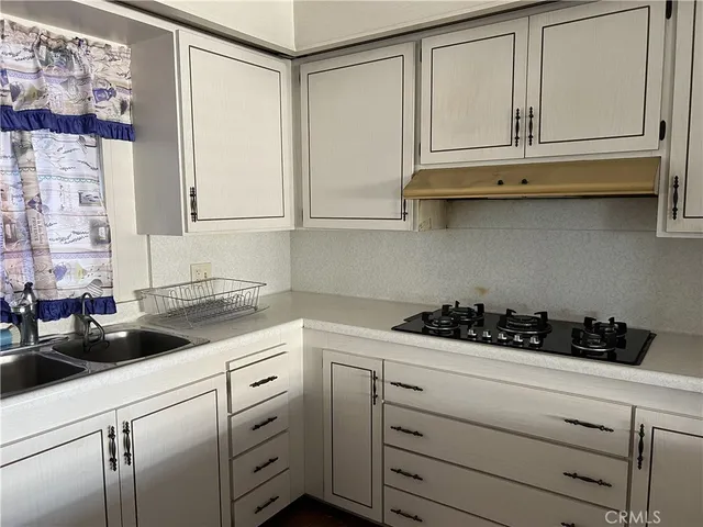 a kitchen with white cabinets and white appliances