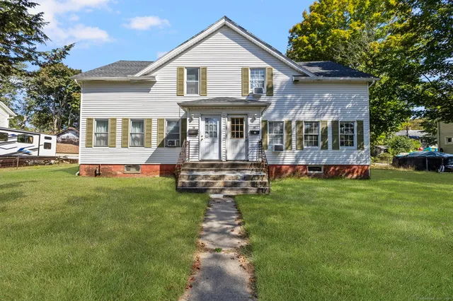 a front view of a house with a yard table and chairs