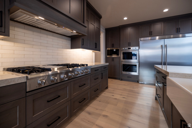 904 South 1900 West Layton, UT 84041 - Photo 8 of 19 Kitchen with exhaust hood, stainless steel appliances, light wood-style floors, dark wood finish cabinets, and recessed lighting