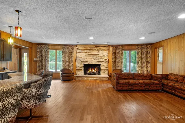 a living room with furniture fireplace and large windows