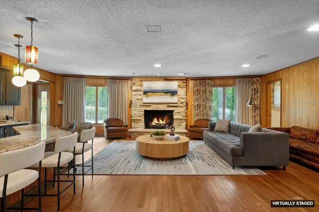 a living room with fireplace furniture and a large window