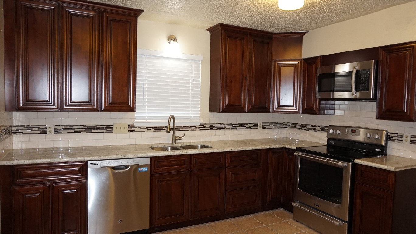 9217 Carousel Lane Houston, TX 77080 - Photo 11 of 38 a kitchen with a sink stove and microwave