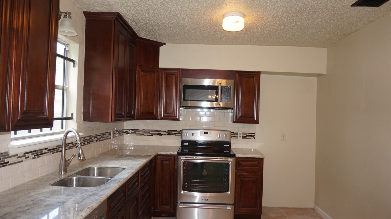 9217 Carousel Lane Houston, TX 77080 - Photo 12 of 38 a kitchen with stainless steel appliances granite countertop a sink and a stove