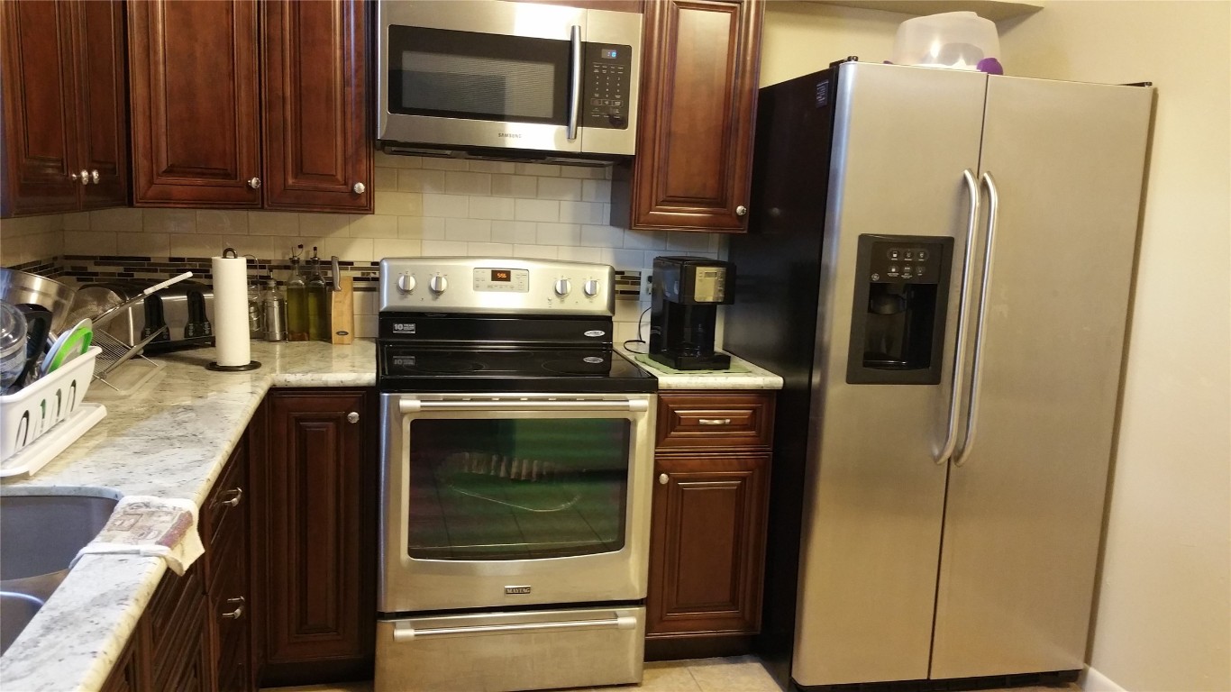 9217 Carousel Lane Houston, TX 77080 - Photo 14 of 38 a kitchen with a refrigerator stove and microwave