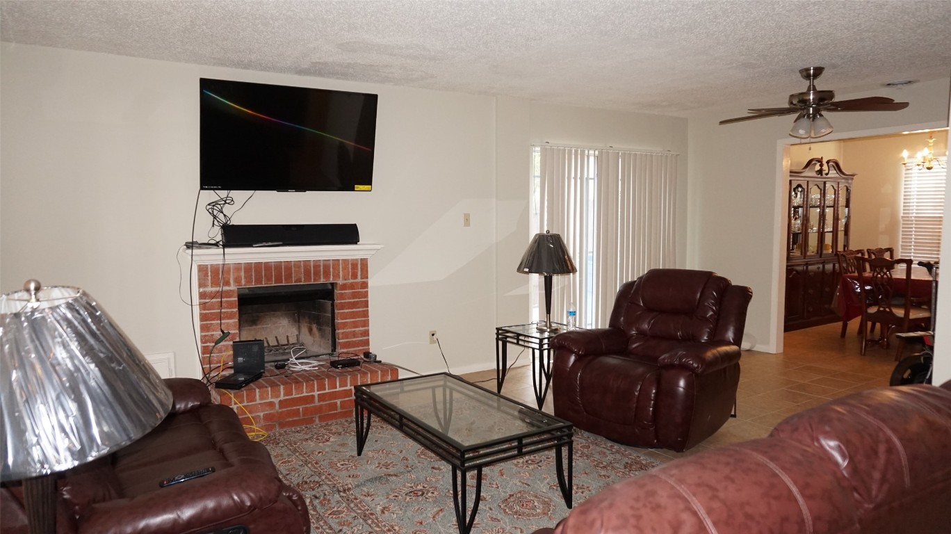 9217 Carousel Lane Houston, TX 77080 - Photo 18 of 38 a living room with furniture a fireplace and a flat screen tv