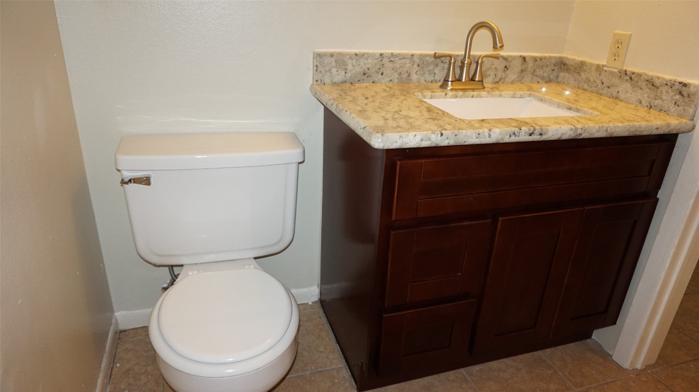 9217 Carousel Lane Houston, TX 77080 - Photo 19 of 38 a bathroom with a granite countertop toilet sink and mirror