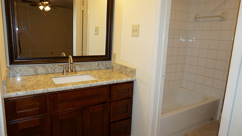 9217 Carousel Lane Houston, TX 77080 - Photo 27 of 38 a bathroom with a granite countertop sink and a mirror