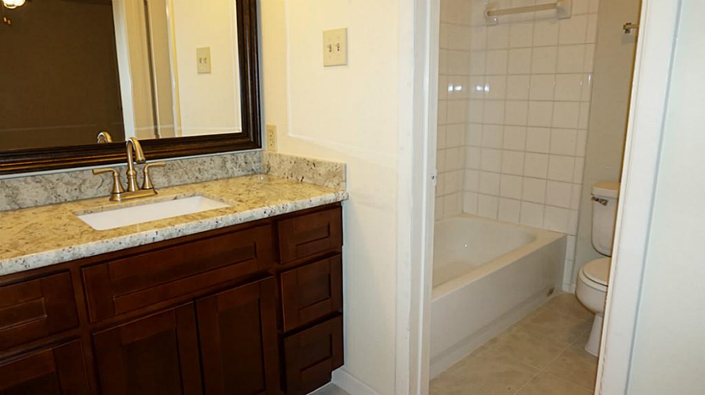 9217 Carousel Lane Houston, TX 77080 - Photo 28 of 38 a bathroom with a granite countertop sink and a mirror