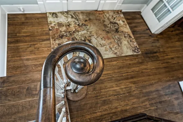 a view of a hallway with wooden floor and staircase