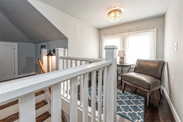 a view of a hallway with wooden floor and staircase