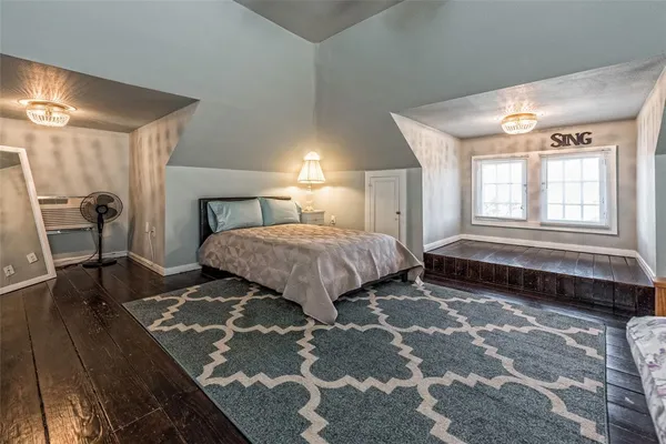 a spacious bedroom with a bed and a chandelier