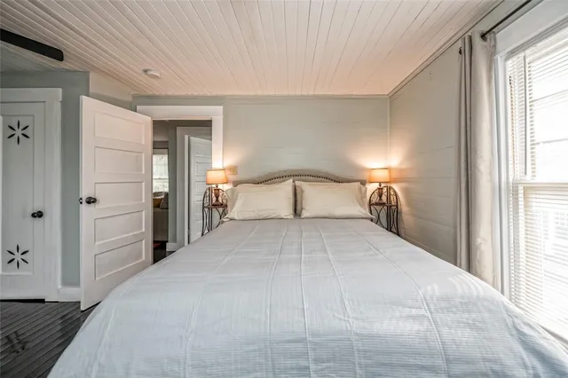 a bedroom with a bed dresser and a window