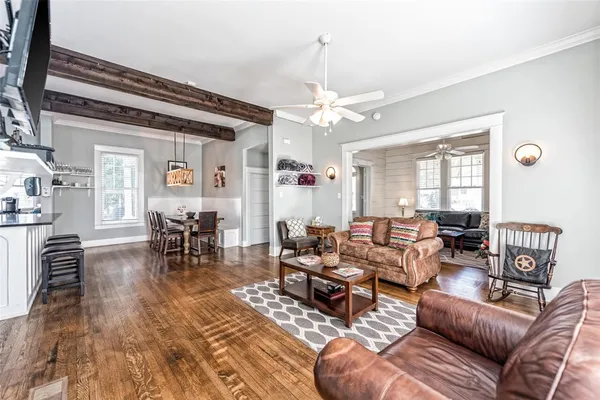 a living room with furniture a wooden floor and a window