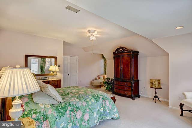 310 South River Landing Road, Unit 310 Edgewater, MD 21037 - Photo 15 of 30 a bedroom with a bed and a chandelier