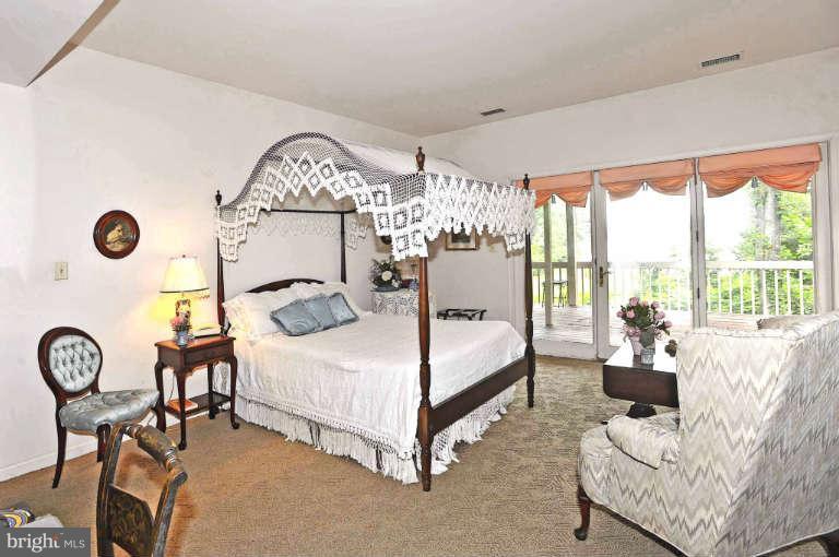 310 South River Landing Road, Unit 310 Edgewater, MD 21037 - Photo 21 of 30 a bedroom with a bed and a chandelier