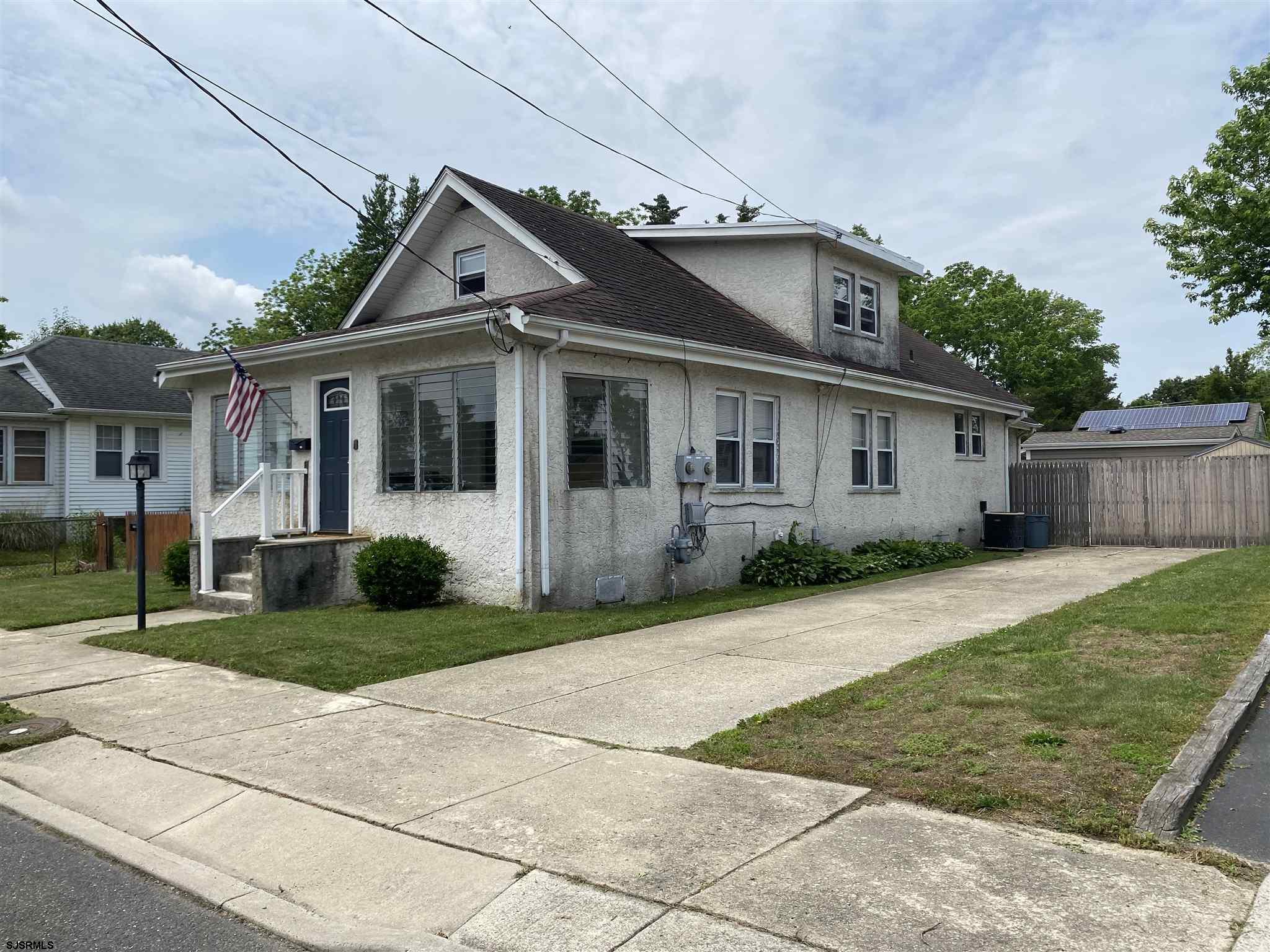 a front view of a house with a garden and trees