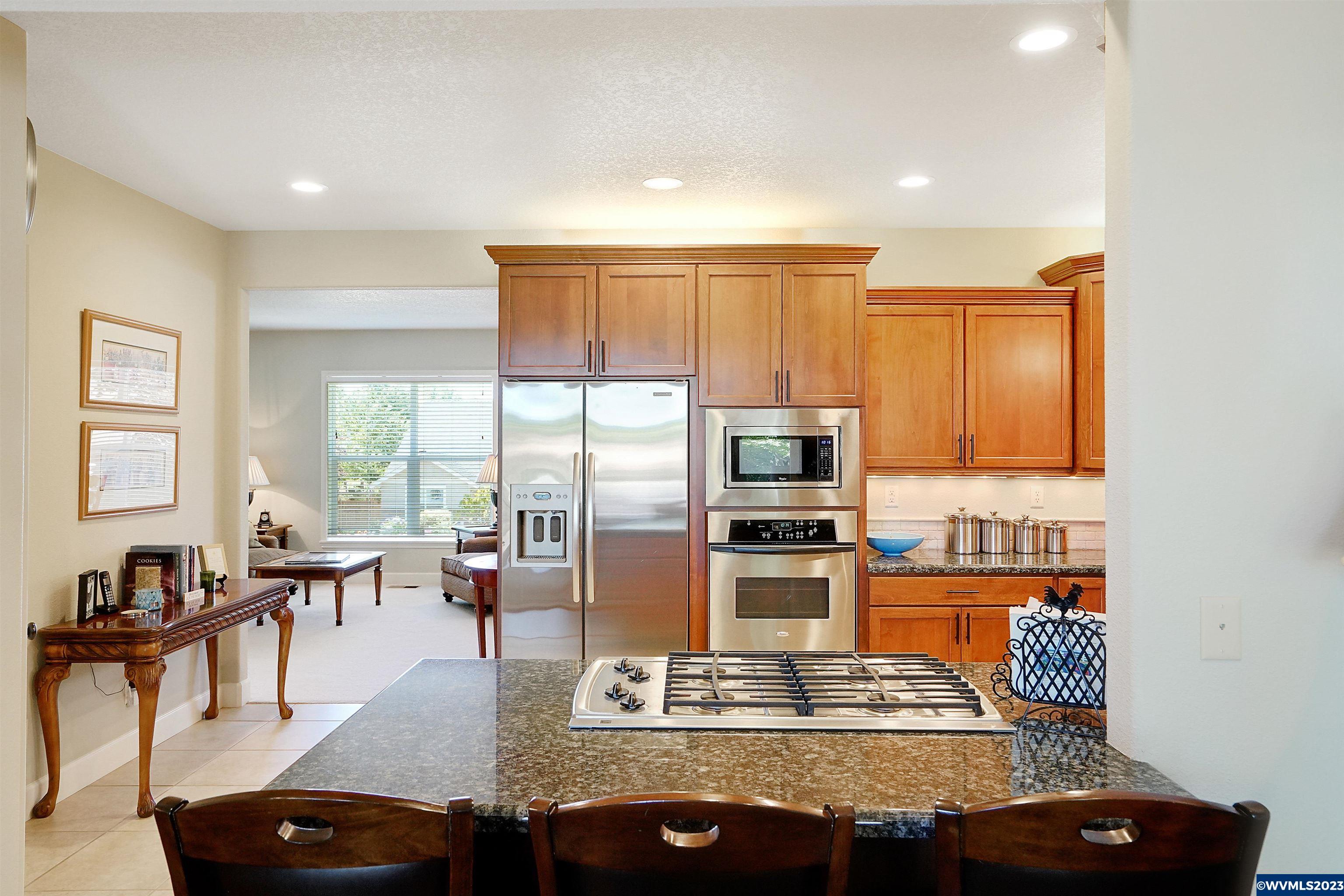 306 Northwest Reed Lane Dallas, OR 97338 - Photo 15 of 42 a living room with stainless steel appliances furniture a rug and a kitchen view