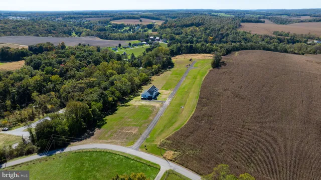 an aerial view of a house with a yard and lake view