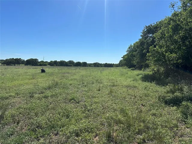 a view of a green field with an ocean view