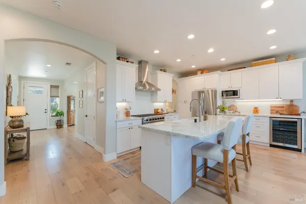 a kitchen with stainless steel appliances kitchen island granite countertop a refrigerator and a stove top oven