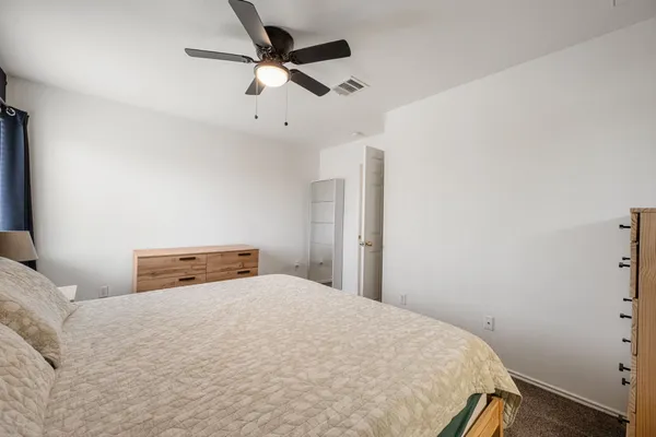 a bedroom with a bed and a ceiling fan