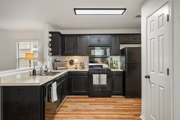 a kitchen with a sink stainless steel appliances and counter space