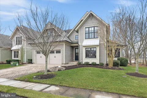 a front view of a house with a yard and trees
