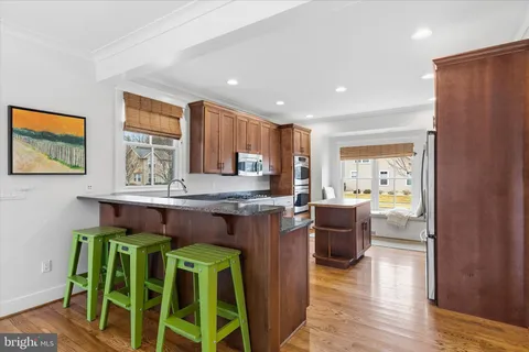a kitchen with granite countertop a sink a stove and cabinets