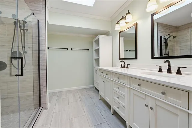 a bathroom with a double vanity sink mirror and shower