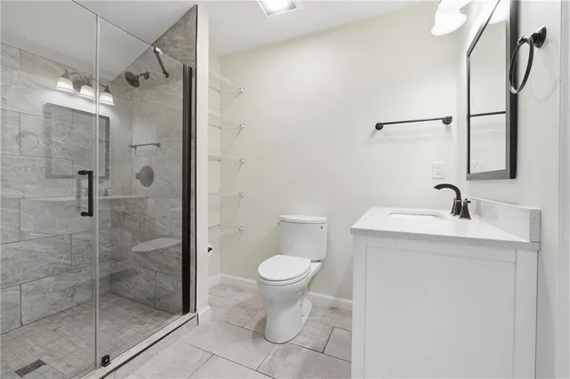 a bathroom with a granite countertop sink a toilet and shower