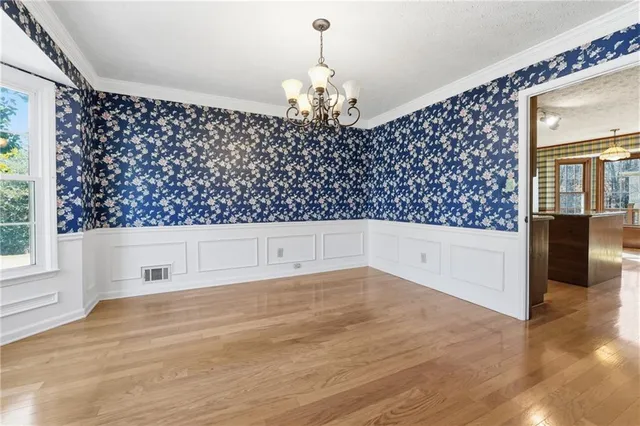 en empty room with wooden floor and windows