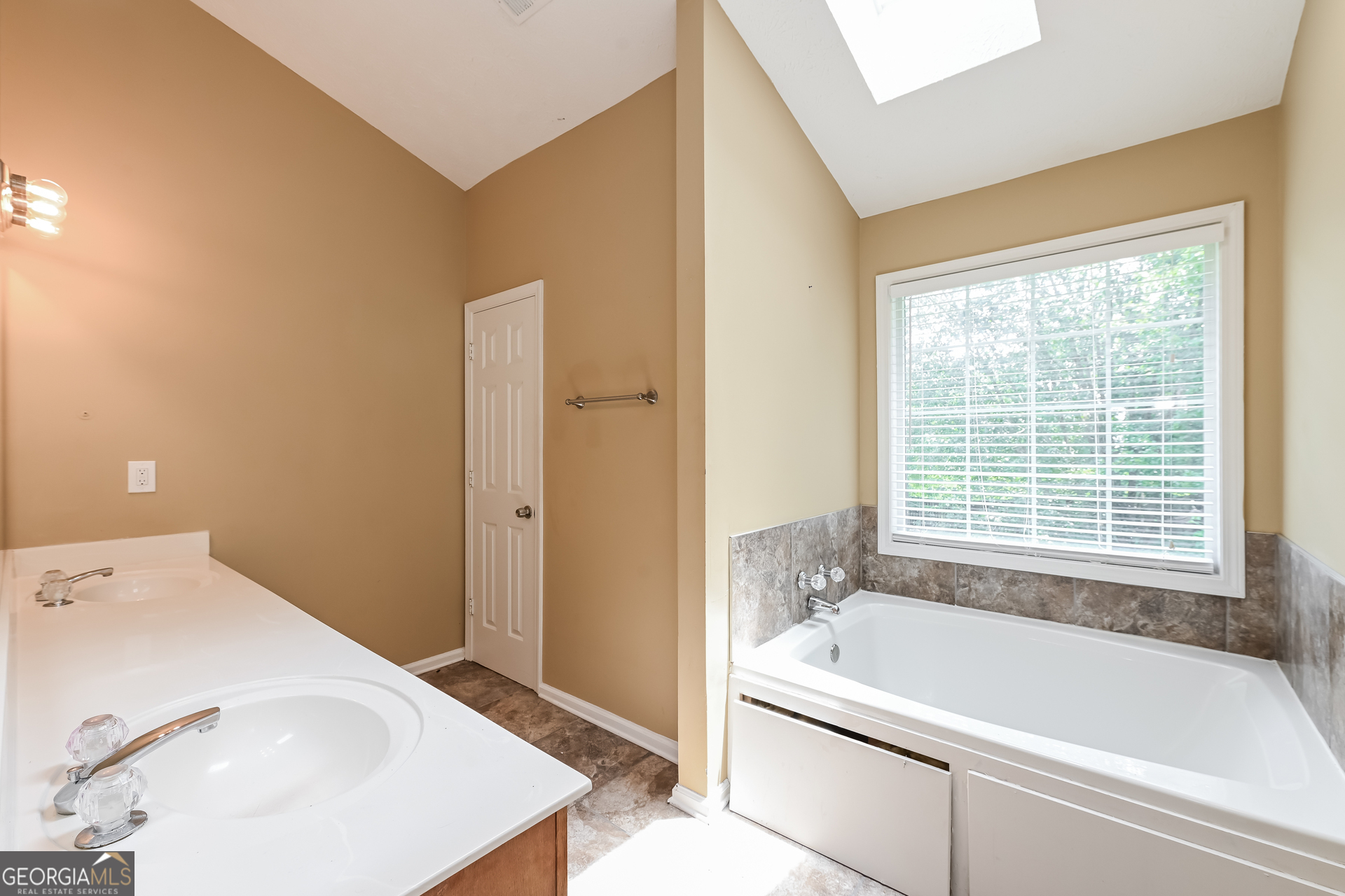 1684 Summit Pl Way Loganville, GA 30052 - Photo 12 of 17 a bathroom with a tub a sink and a window