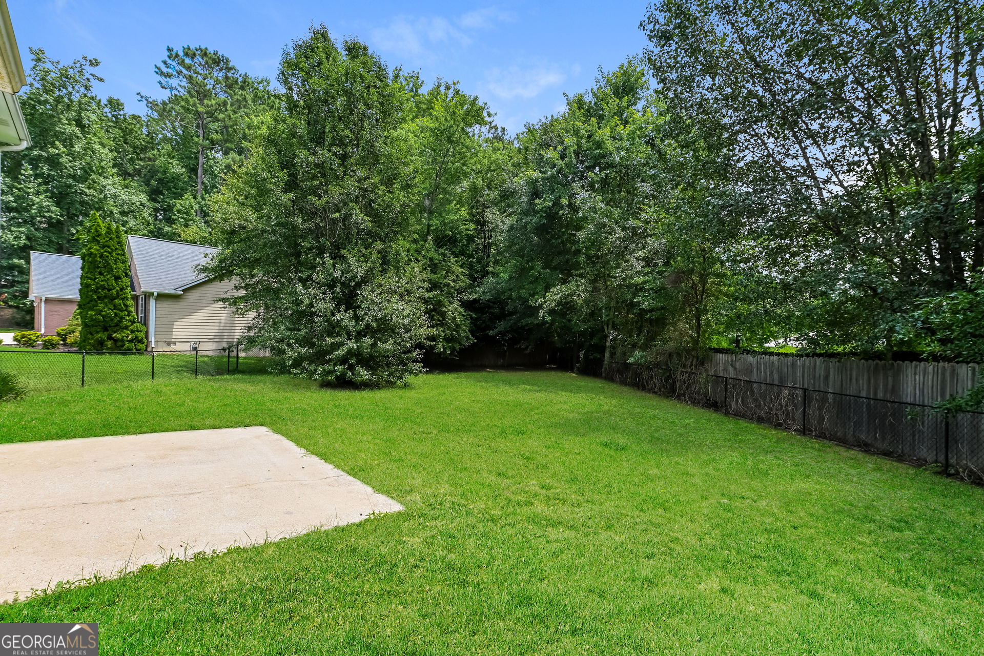 1684 Summit Pl Way Loganville, GA 30052 - Photo 17 of 17 a view of a backyard with a house and large trees