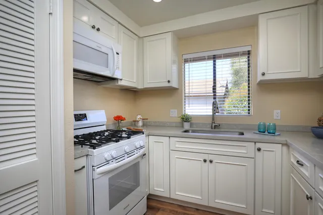 a kitchen with stainless steel appliances a sink stove and cabinets