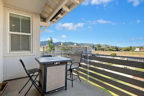 a view of a terrace with furniture and city view