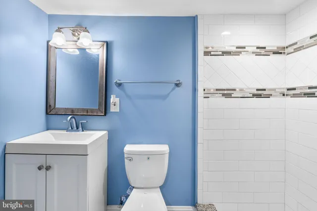 a bathroom with a toilet sink and mirror