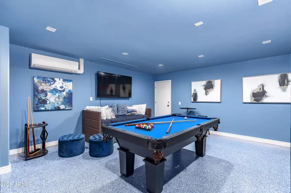 a living room with furniture pool table and a flat screen tv