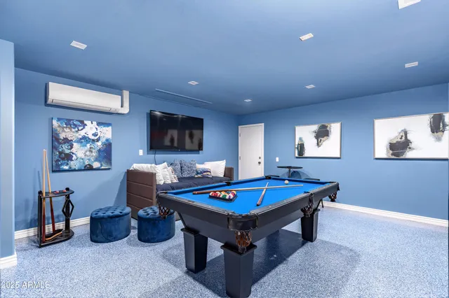 a living room with furniture pool table and a flat screen tv