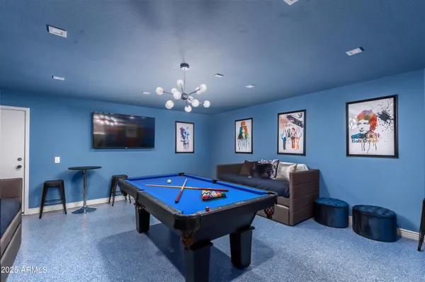 a living room with furniture pool table and a flat screen tv