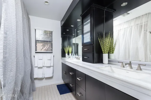 a bathroom with a double vanity sink mirror and bathtub