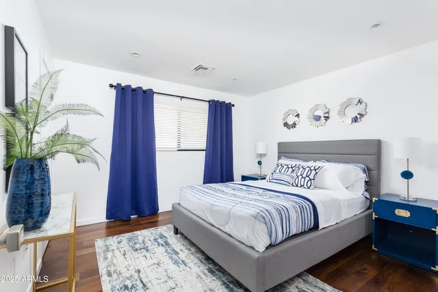 a bedroom with a large bed and a potted plant
