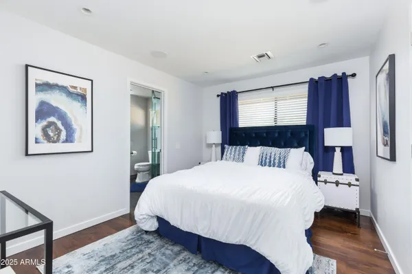 a bedroom with a bed and a painting on the wall