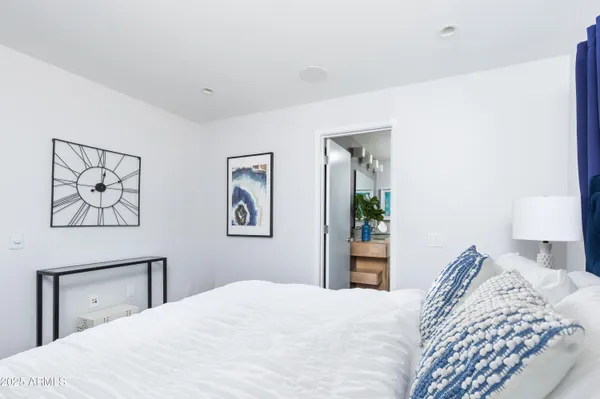 a bedroom with a large bed and a chandelier
