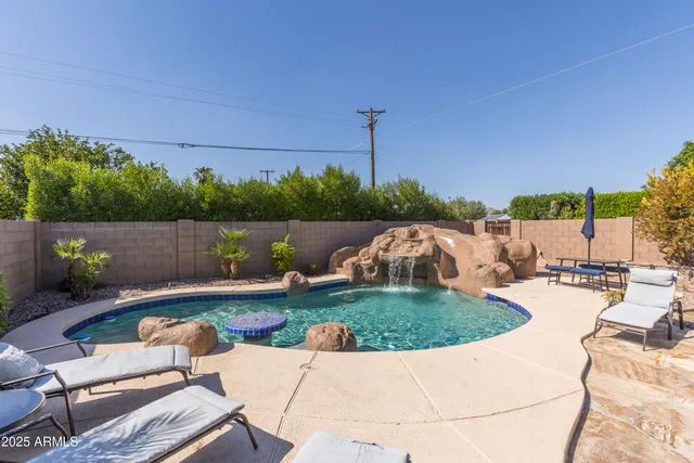 a living room with patio furniture and a potted plant