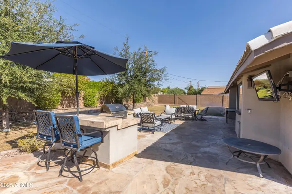 a view of a patio with dining table and chairs